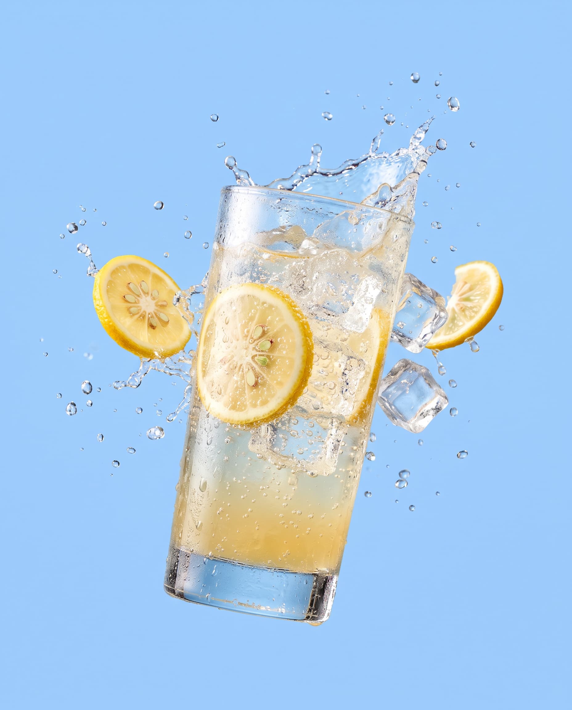 A sparkling yuzu soda with citrus wheels and ice floating on sky blue